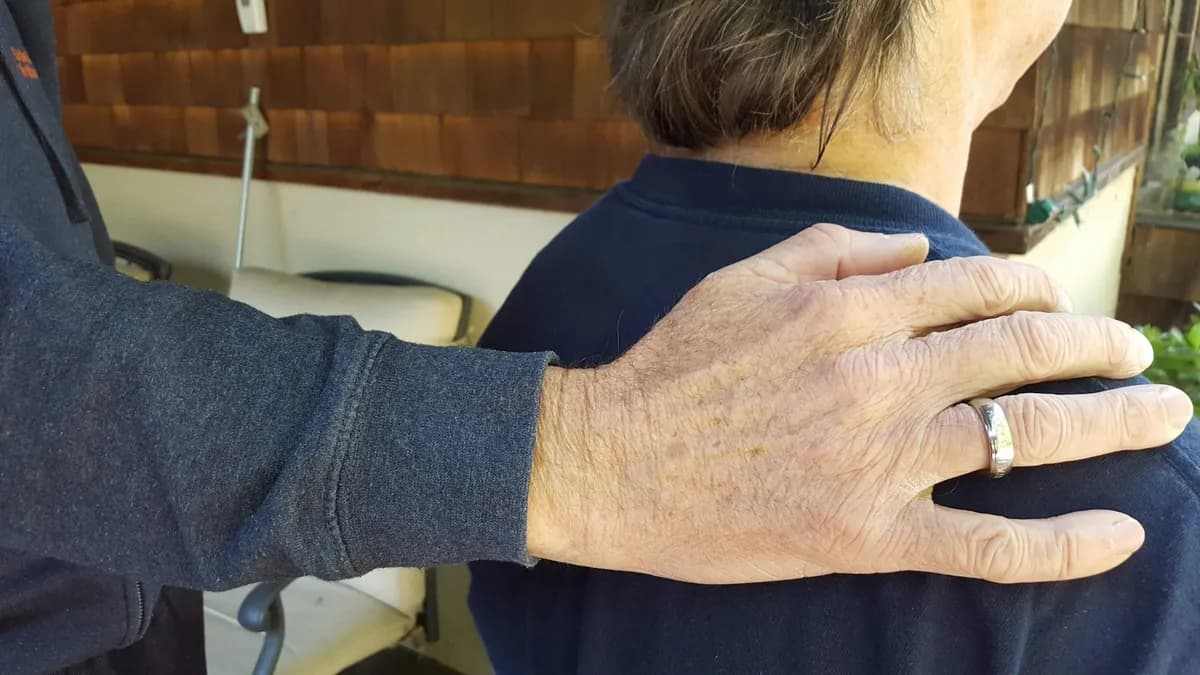 A comforting hand on someone's shoulder